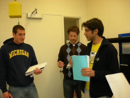 3 people having a discussion while holding notebooks
